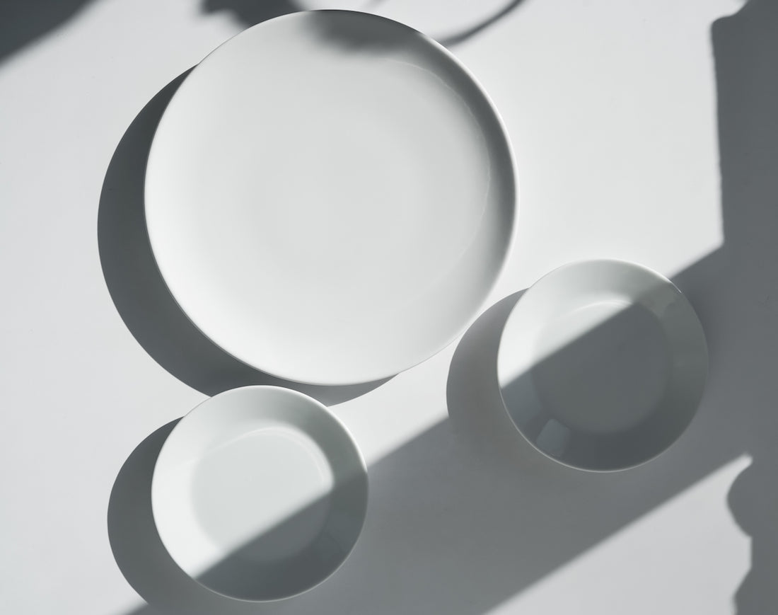 a white plate and two white bowls on a table