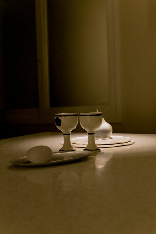 Two egg cups and an egg on a table.