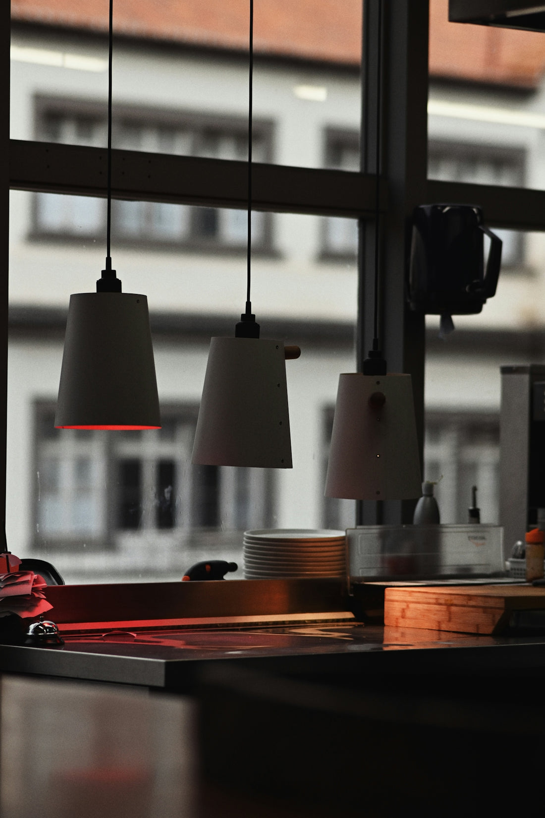 Three pendant lights hang over a kitchen counter.